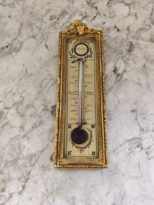 un thermomètre mural accroché à un mur en marbre