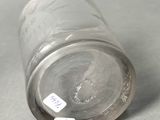 a glass with a sticker on it sitting on a table