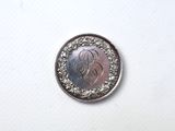 a close up of a silver coin with a monogram on it