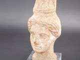 une image représentant un vase orné d'une tête de femme