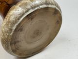 a brown vase with a tree on it on a white surface