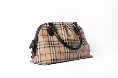 le petit sac vintage à carreaux est posé sur une surface blanche