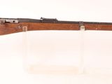 un vieux fusil accroché au mur, avec un porte-lunette