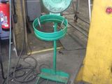 a green trash can sitting on a stand in a garage