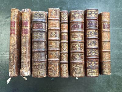 six vieux livres alignés en rang sur une table