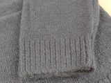 a close up of a gray sweater with a long sleeve