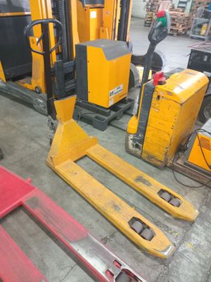 a fork lift truck parked in a warehouse next to other pallets