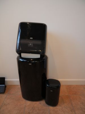 a black trash can sitting next to a black trash can