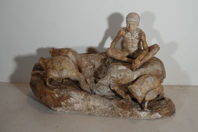 une statue représentant un homme assis sur un rocher avec un chien