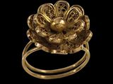 une image représentant une bague en or avec une fleur au centre