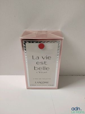 a close up of a box of perfume on a white surface