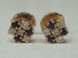 une paire de boucles d'oreilles à clous en forme de diamant, bleues et blanches, posées sur un fond blanc