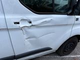 a white van that has been damaged and is parked in a parking lot
