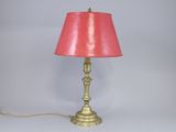 a lamp that is on a table with a pink shade on it