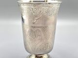 an antique silver cup with a floral design on the rim
