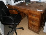 un bureau avec un ordinateur et une chaise dans un coin