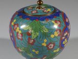 une image représentant un vase bleu orné de fleurs et de feuilles peintes