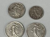 four different types of silver coins on a white surface