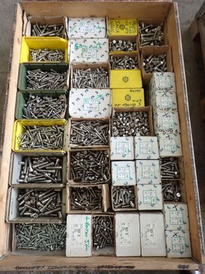 many boxes of screws in a box on the floor