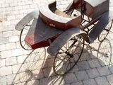 a old fashioned buggy sitting on a cobblestone street