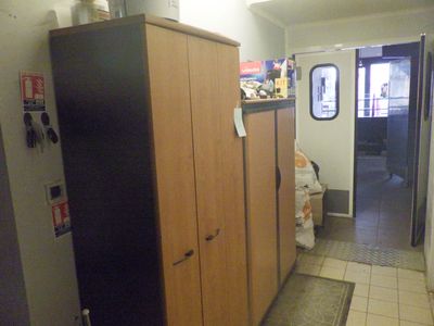 un réfrigérateur dans un coin de la pièce, près d'une porte