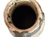 an old rusted vase with a hole in it