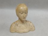a small statue of a woman with a hat on her head