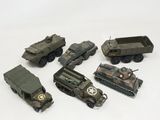 several toy army vehicles are lined up on a white surface