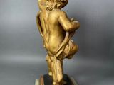 an image of a statue of a boy holding a bird on a pedestal