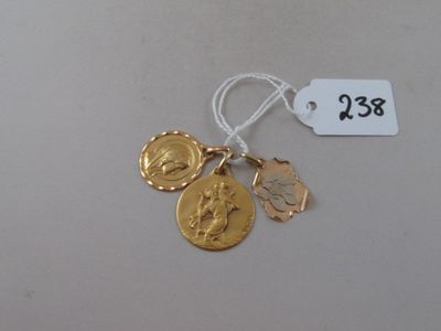 a gold coin and a gold medal on a white string