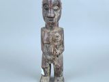 une vieille statue en bois représentant un homme tenant un bébé dans ses bras