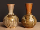 deux vases posés sur une table, sur fond noir
