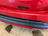 a close up of a red car parked in a garage