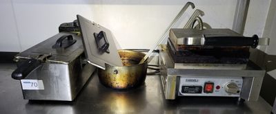 two deep fryers sitting on a stainless steel counter top