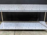 une table carrelée de blanc, surmontée de deux étagères