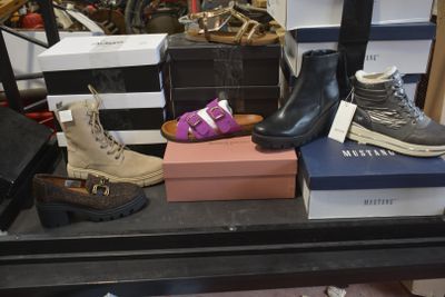 several pairs of shoes are sitting on a shelf in a shoe store