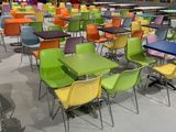 des chaises et des tables aux couleurs vives dans une aire de jeux, avec un toboggan en arrière-plan