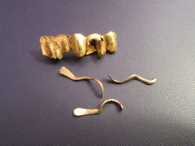 a pair of scissors and a gold earring on a table