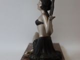 a statue of a woman holding a baseball bat on a table