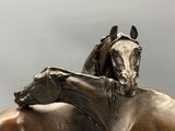 une statue en bronze représentant un cheval et un autre cheval allongé sur son dos