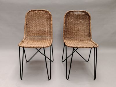 une paire de chaises en osier avec des pieds en fer noir