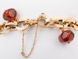 gold plated bracelet with red glass beads and a gold chain