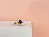 an image of a gold ring with a blue stone in the middle of it