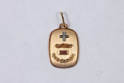 un gros plan sur un petit pendentif en or orné d'une croix