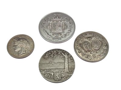 four different types of silver coins on a white surface