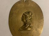 an image of a gold medallion with a man ' s head on it