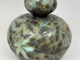 a close up of a vase on a white surface