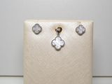 un gros plan sur un sac à main blanc sur lequel sont posées une paire de boucles d'oreilles
