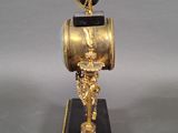 a gold and black clock that is on a stand