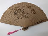 a fan with a design on it on a table